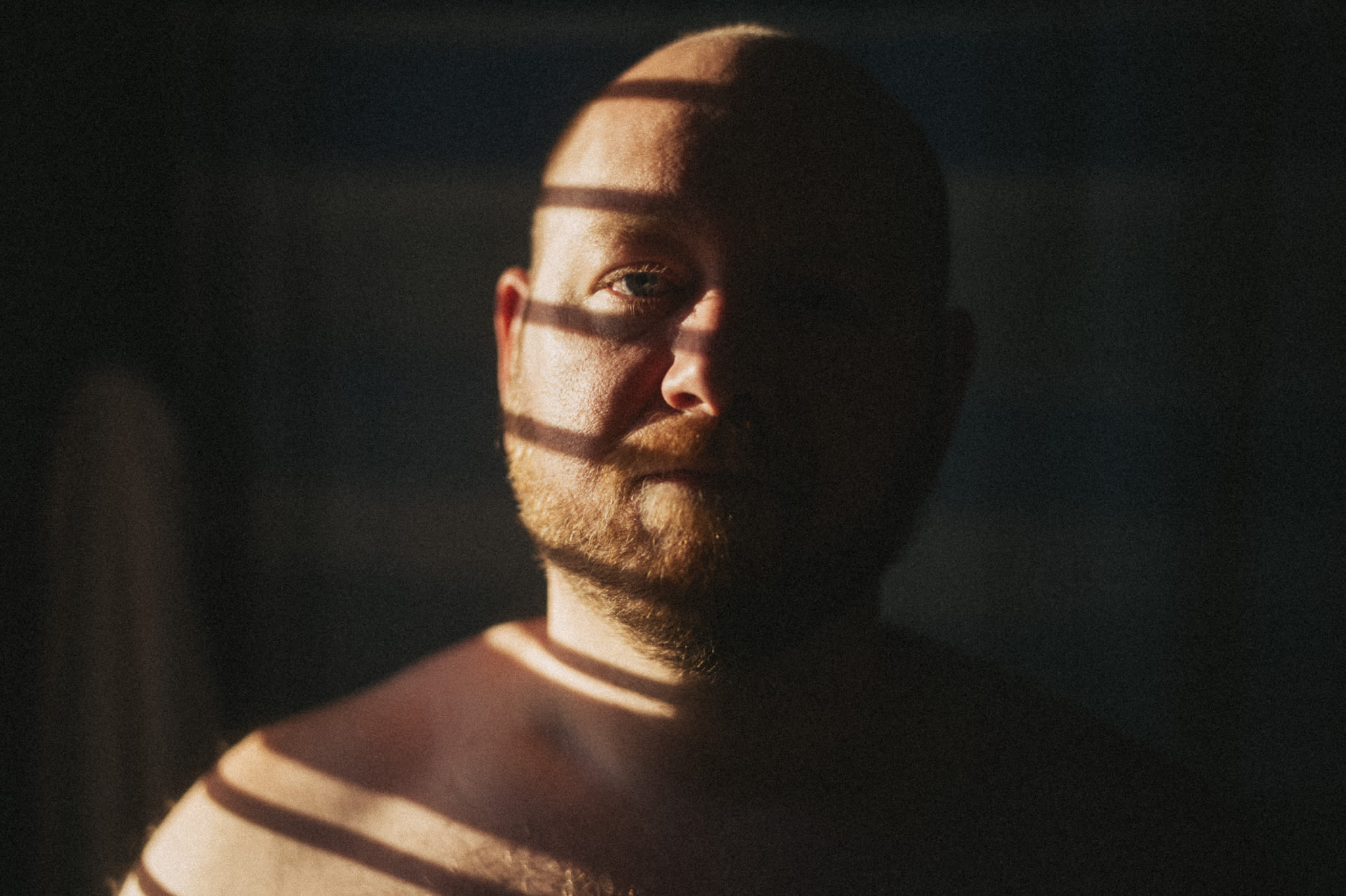 man with stripes of light spilling on his face