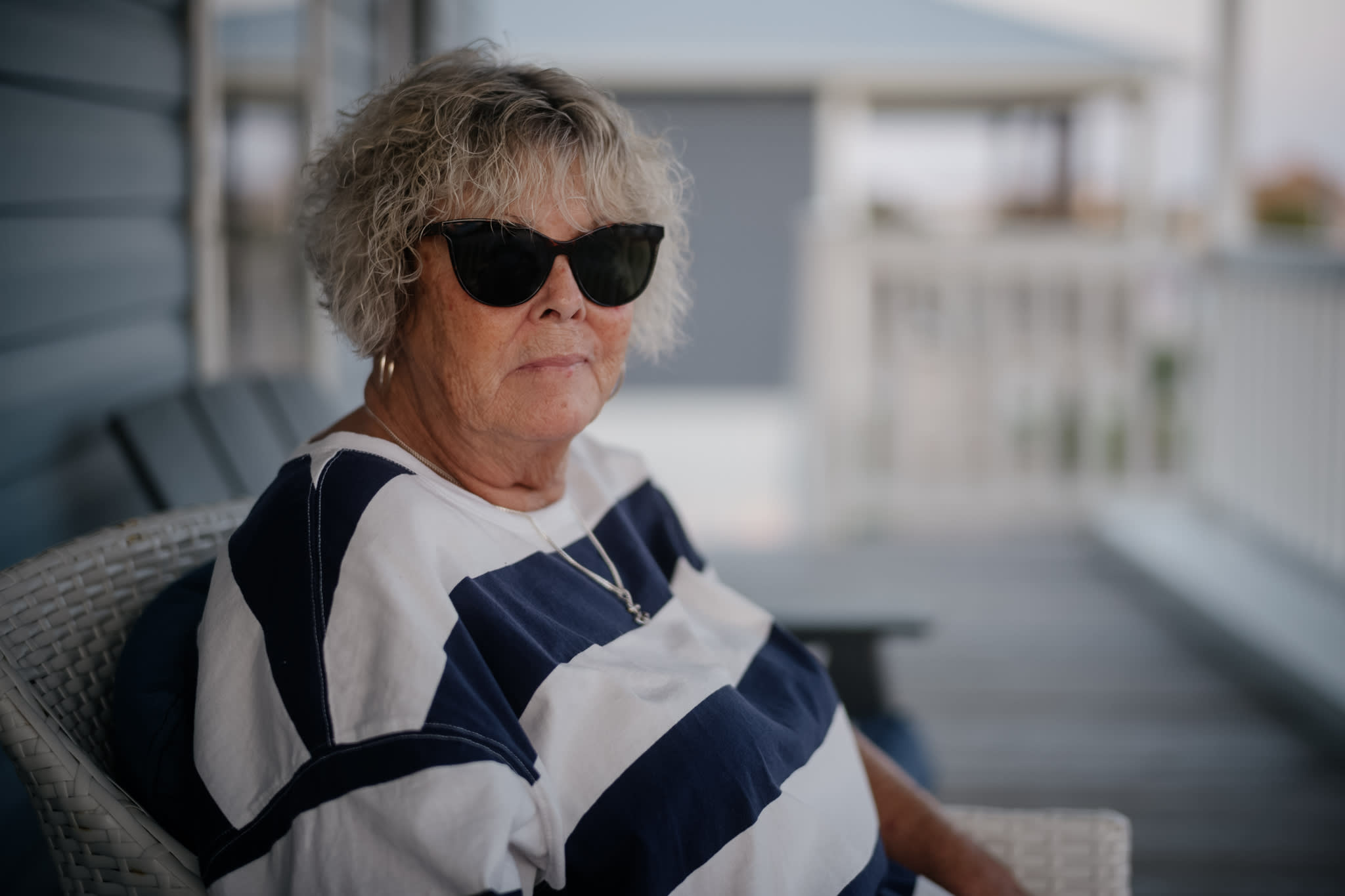 older woman wearing sunglasses and a striped shirt