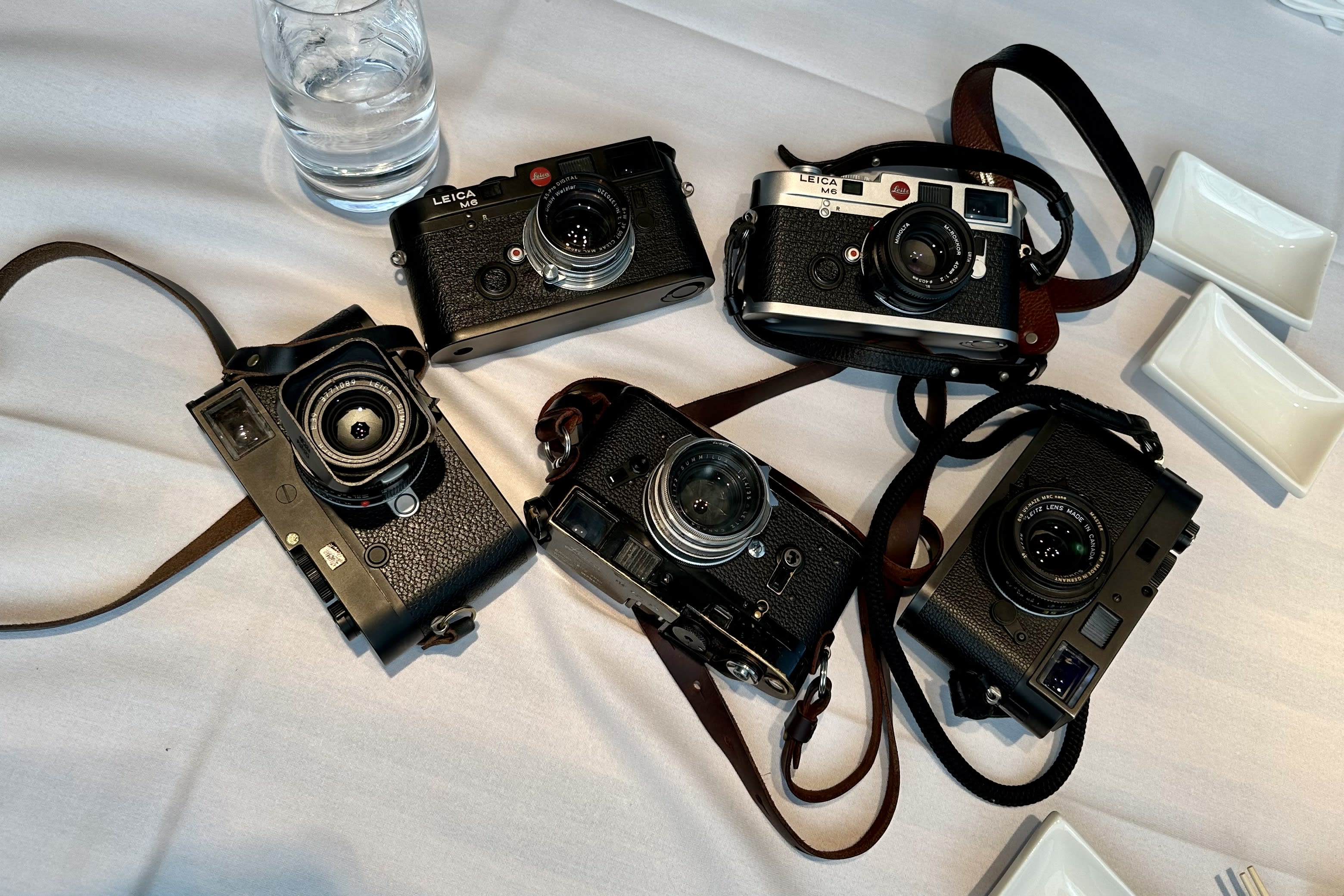 five leica cameras sitting on a restaurant table