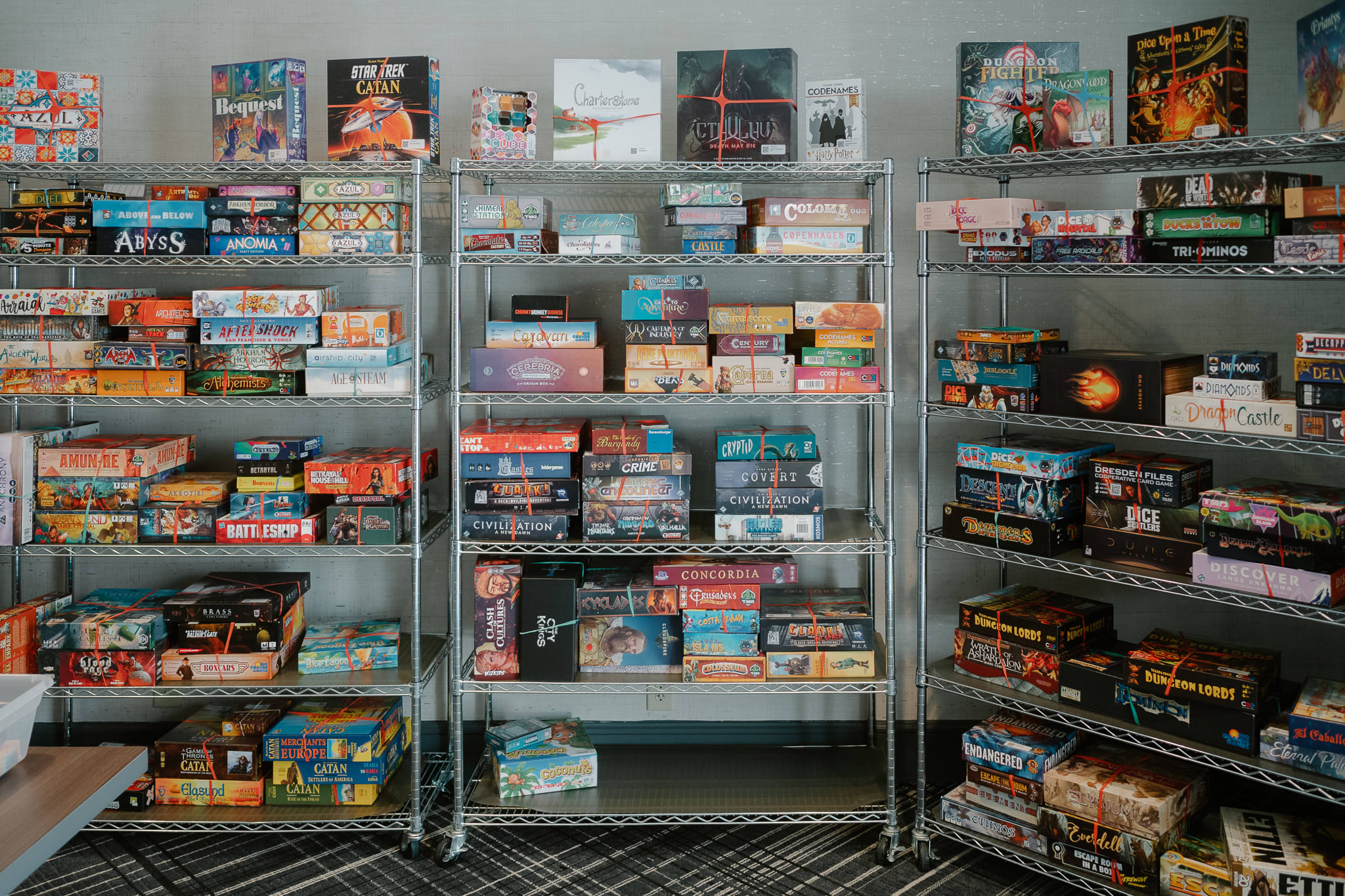 a wall lined with wire shelving full of different board games