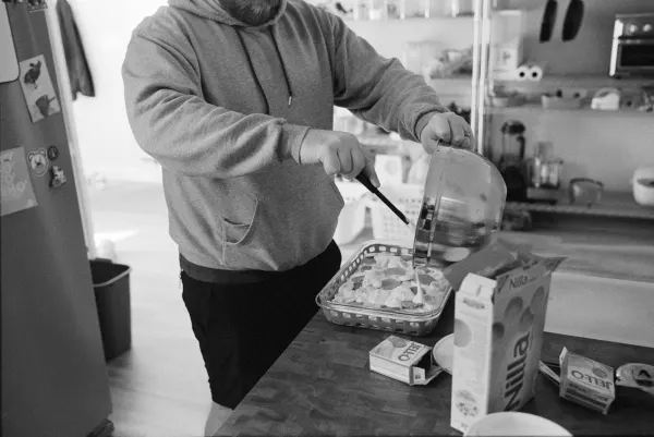 man scraping pudding into dessert dish from a bowl