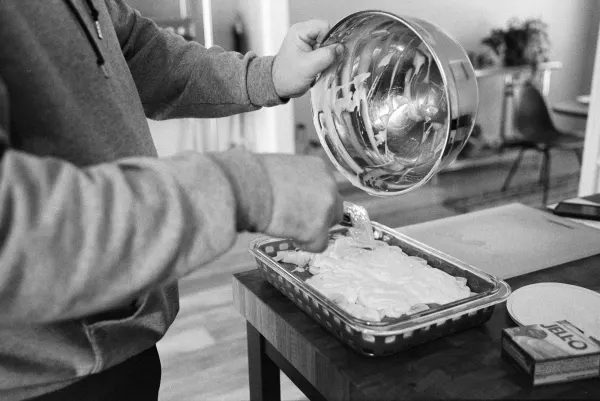 man scooping pudding from a bowl into dish