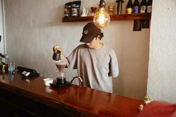 A young male barista making a pour over