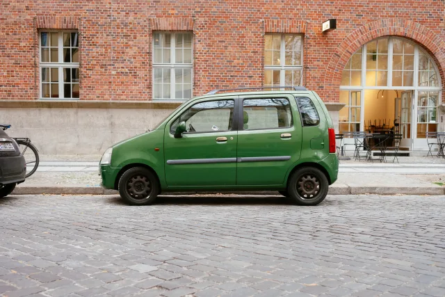 a view of the side of a very small four door car parked on the street