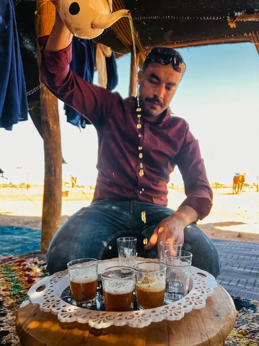 Guide Hasy Pouring Traditional Moroccan Mint Tea in Desert Camp