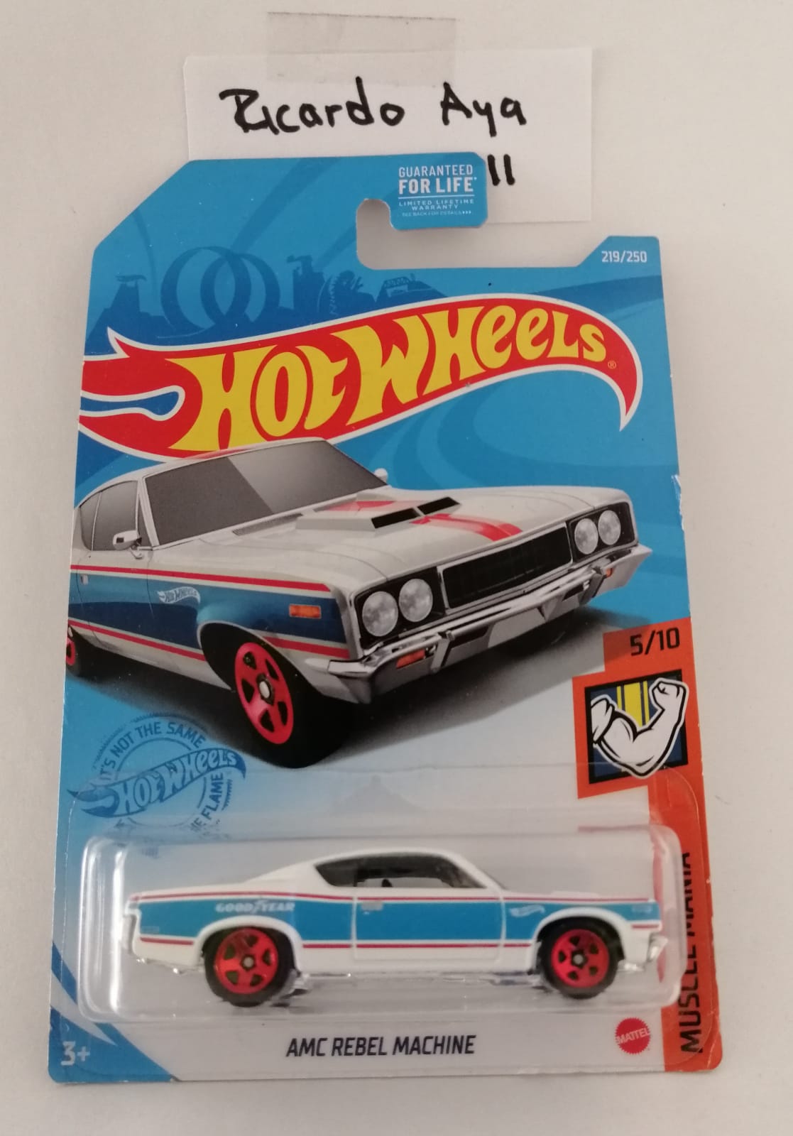 Front of satchel with blue canvas body, black straps and handle, drawstring top, and front zipper pouch.