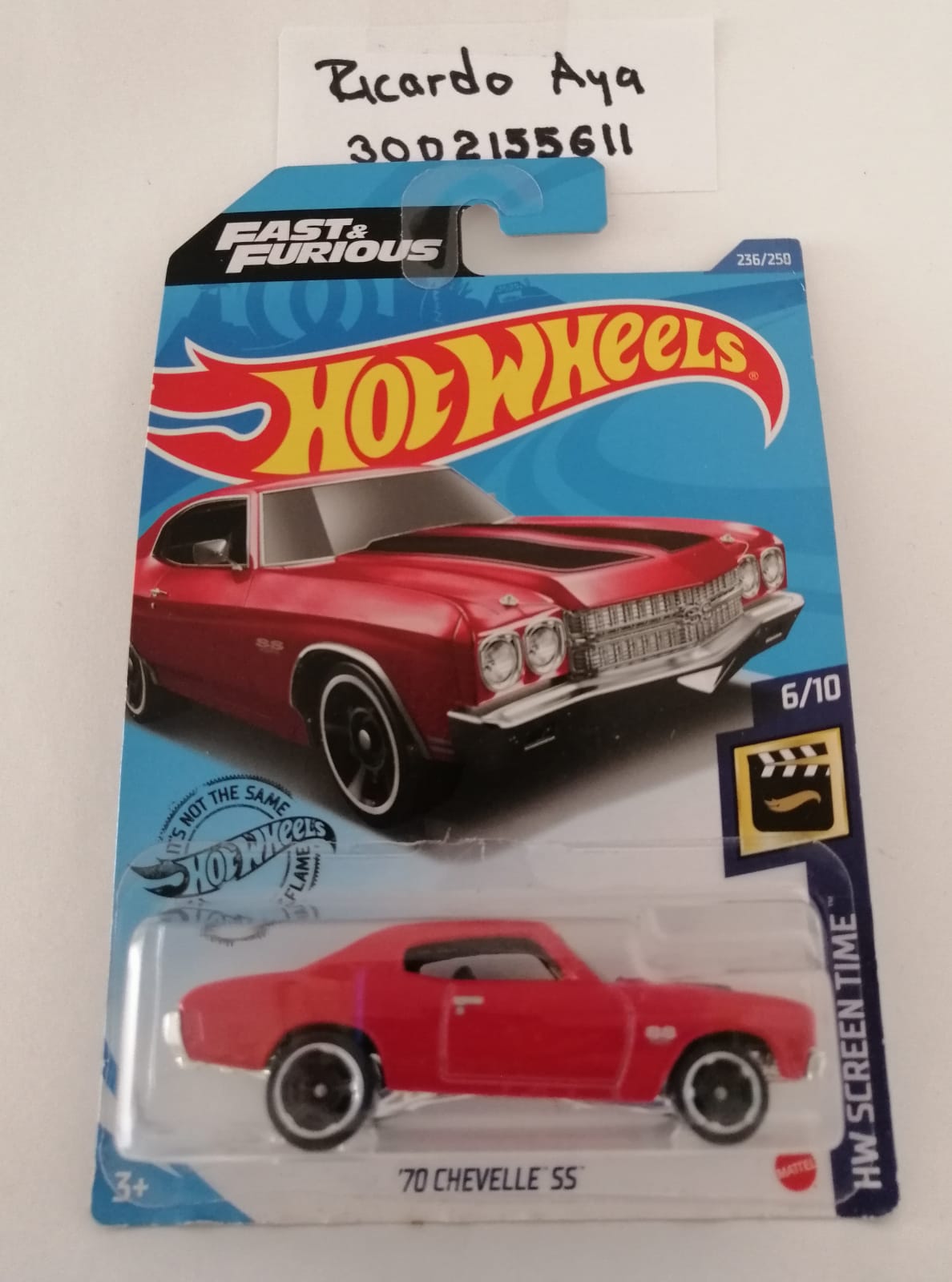 Front of satchel with blue canvas body, black straps and handle, drawstring top, and front zipper pouch.