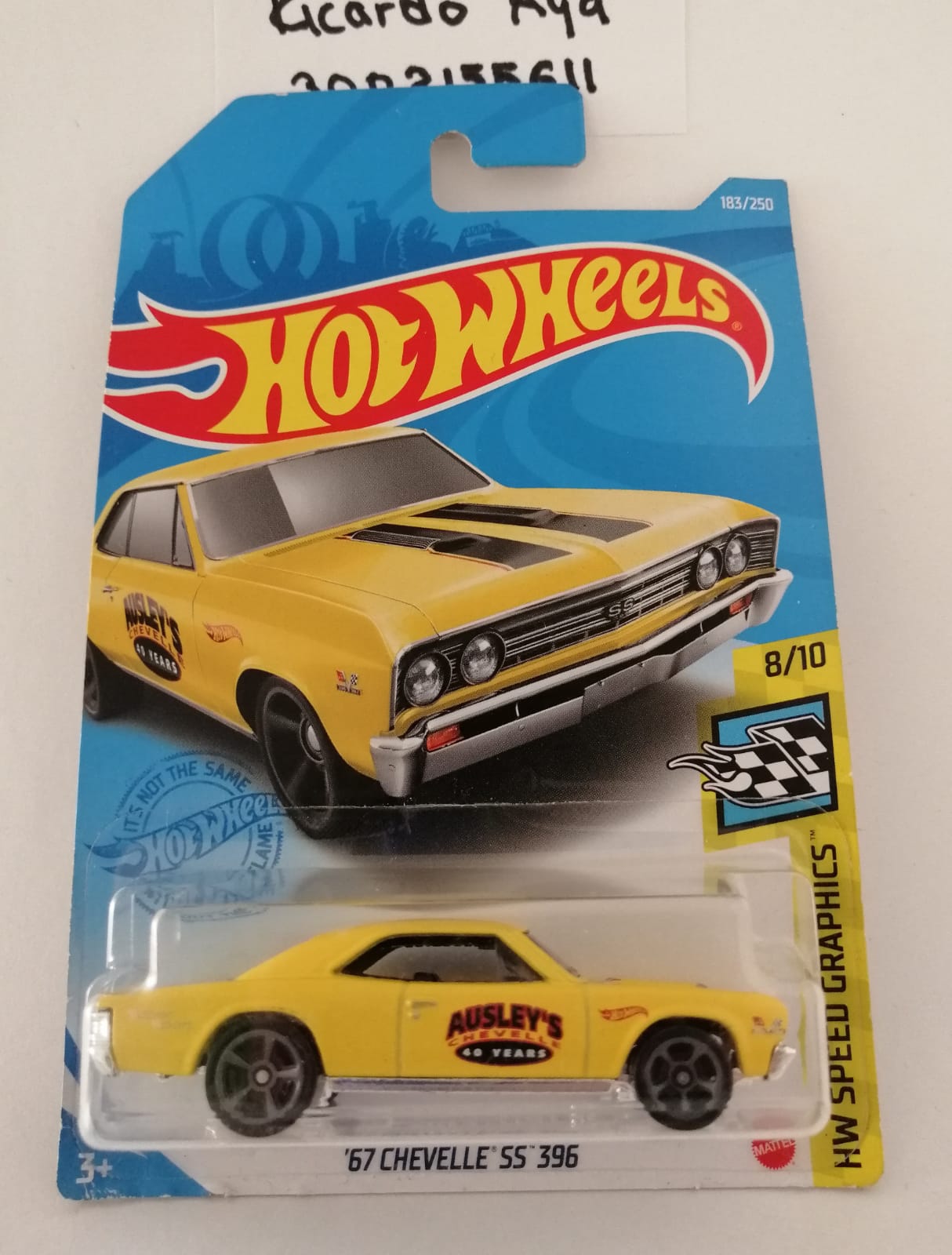 Front of satchel with blue canvas body, black straps and handle, drawstring top, and front zipper pouch.