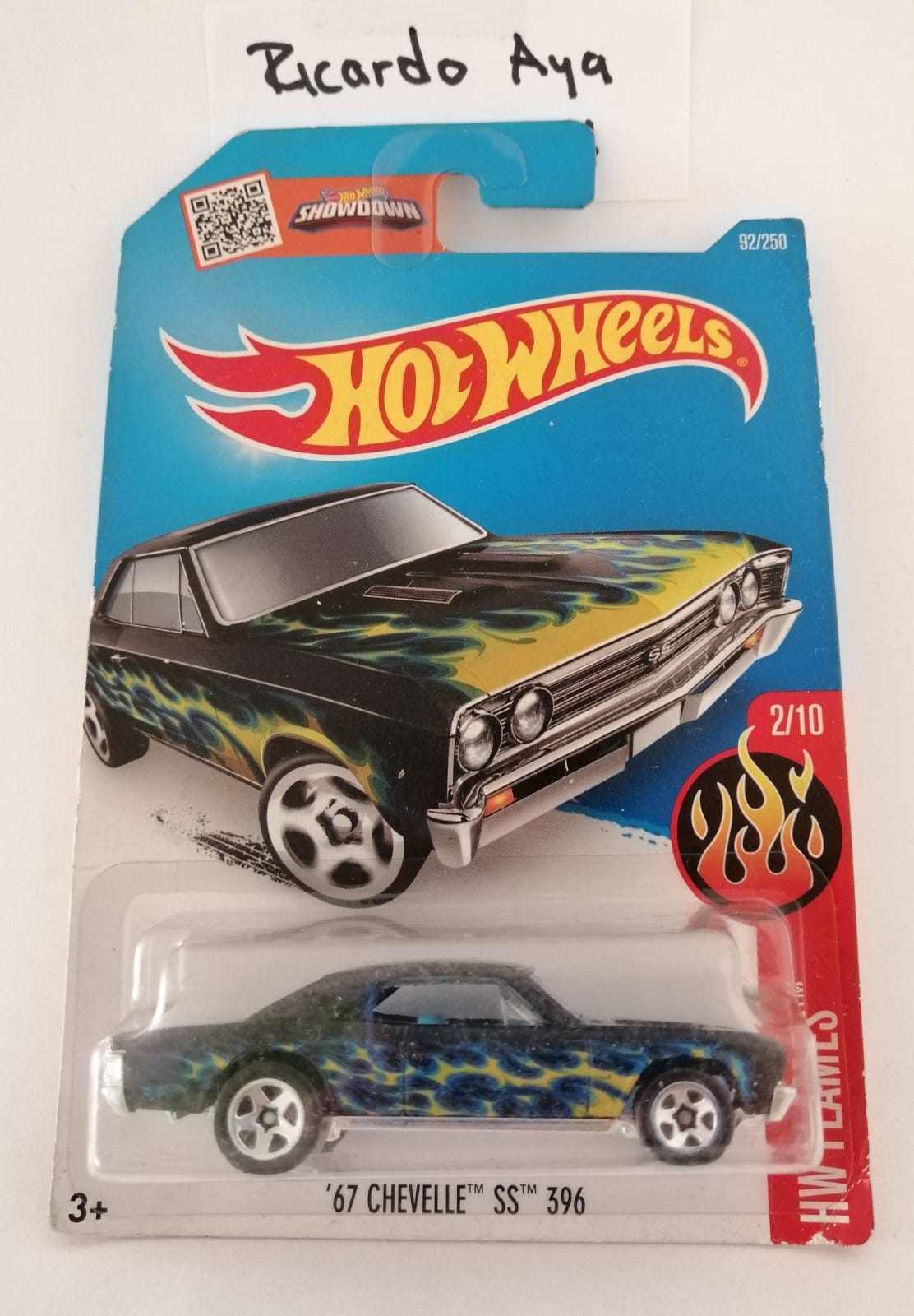 Front of satchel with blue canvas body, black straps and handle, drawstring top, and front zipper pouch.