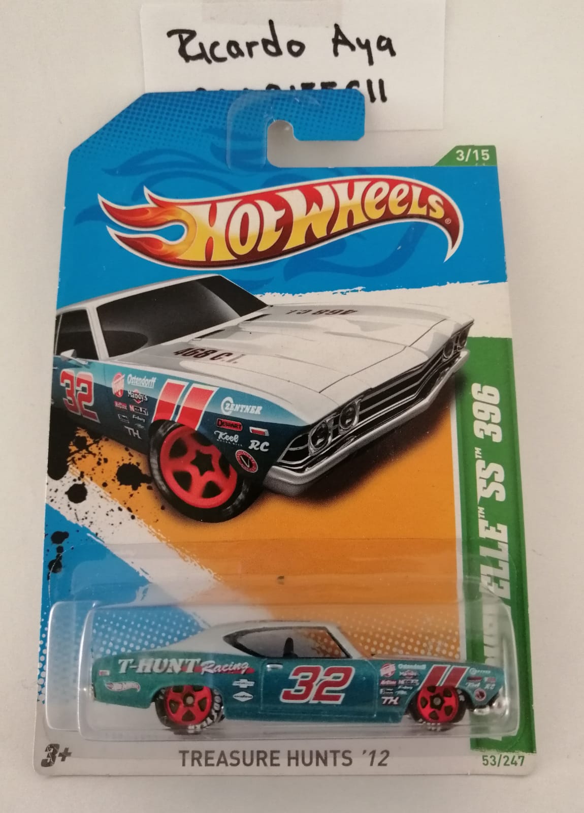 Front of satchel with blue canvas body, black straps and handle, drawstring top, and front zipper pouch.