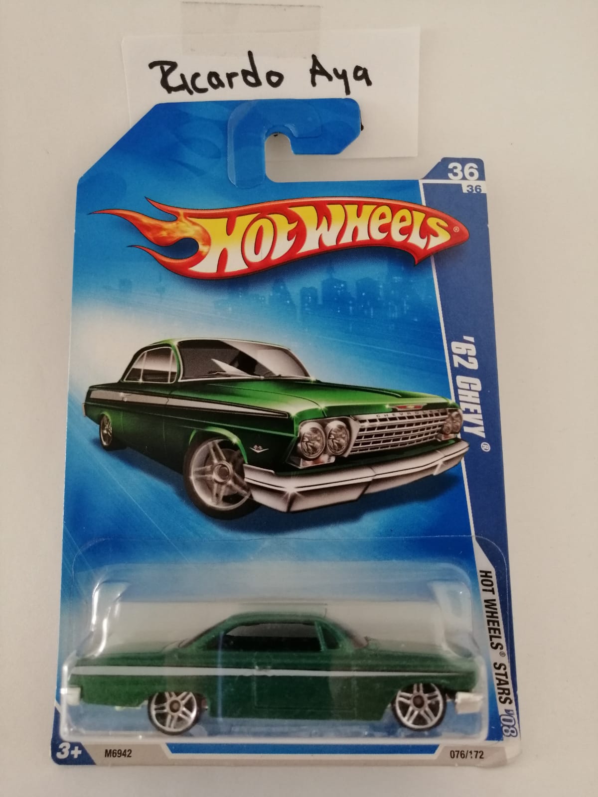 Front of satchel with blue canvas body, black straps and handle, drawstring top, and front zipper pouch.