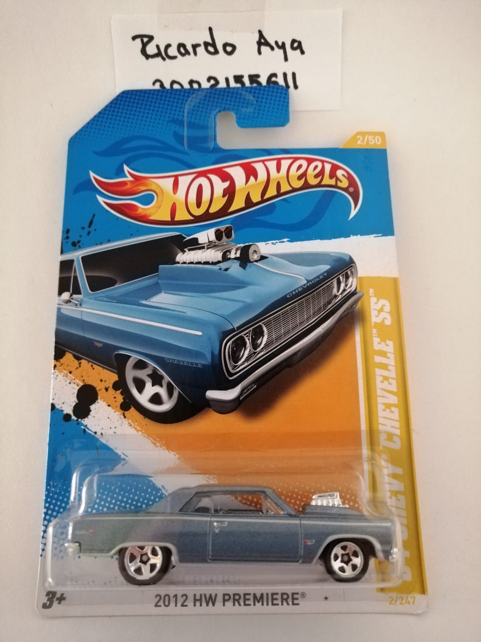 Front of satchel with blue canvas body, black straps and handle, drawstring top, and front zipper pouch.