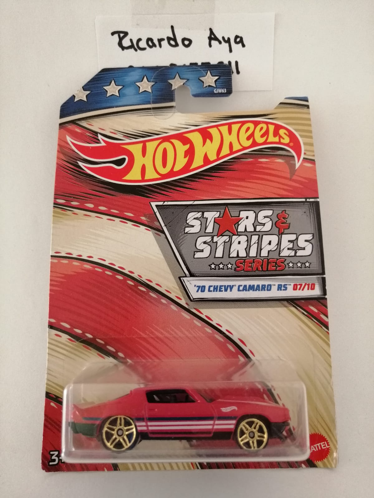 Front of satchel with blue canvas body, black straps and handle, drawstring top, and front zipper pouch.