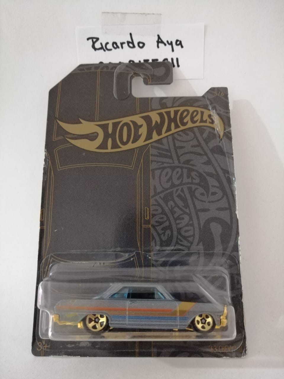 Front of satchel with blue canvas body, black straps and handle, drawstring top, and front zipper pouch.