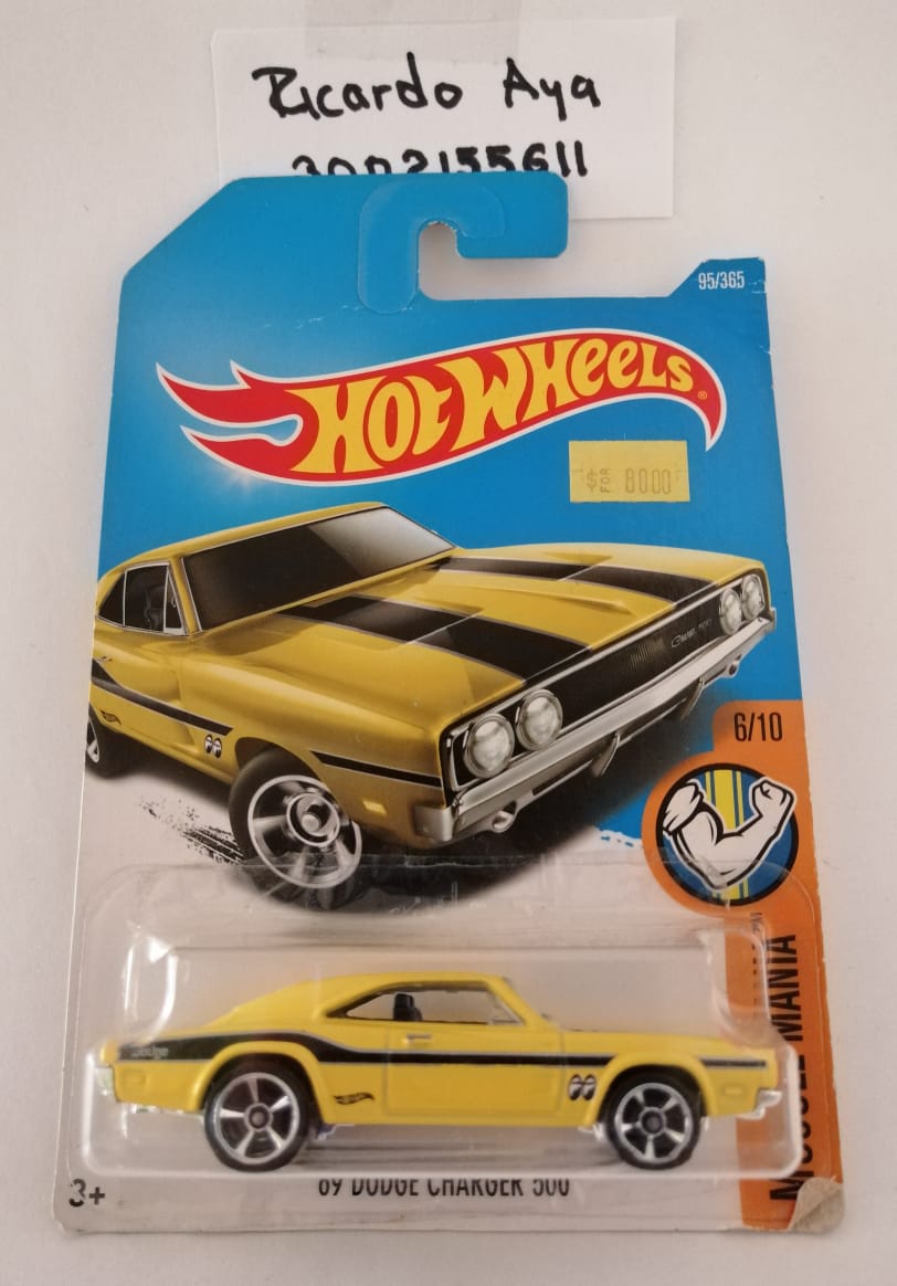 Front of satchel with blue canvas body, black straps and handle, drawstring top, and front zipper pouch.