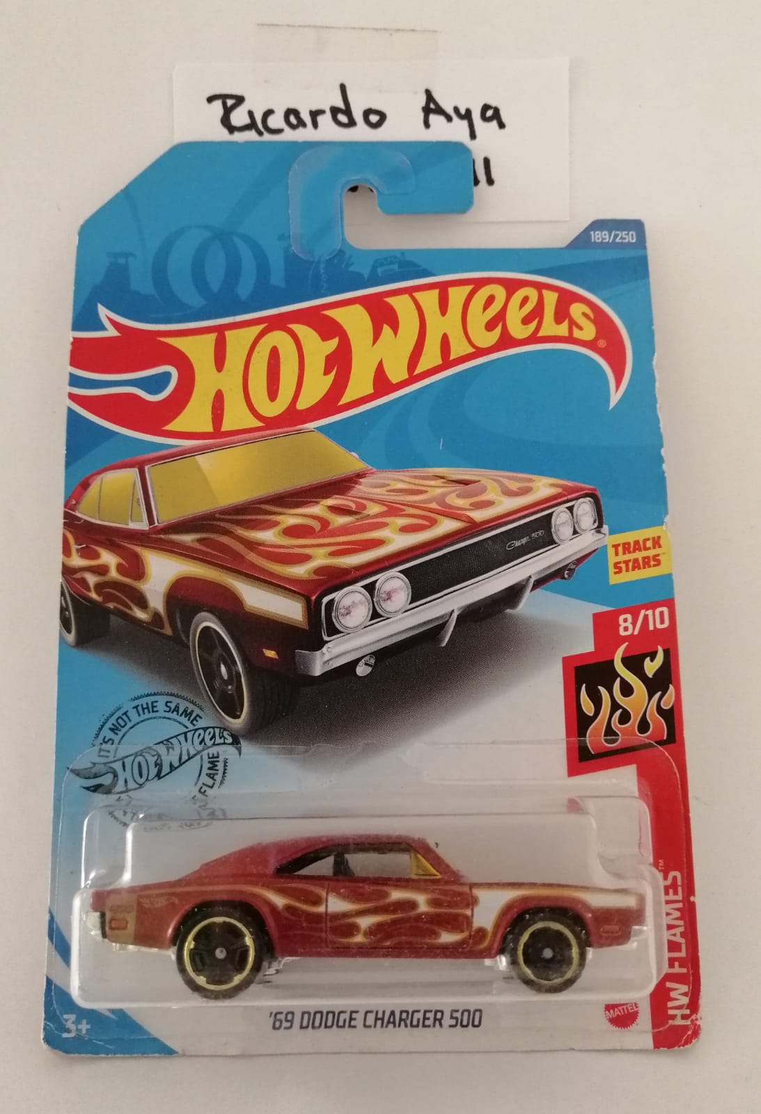 Front of satchel with blue canvas body, black straps and handle, drawstring top, and front zipper pouch.