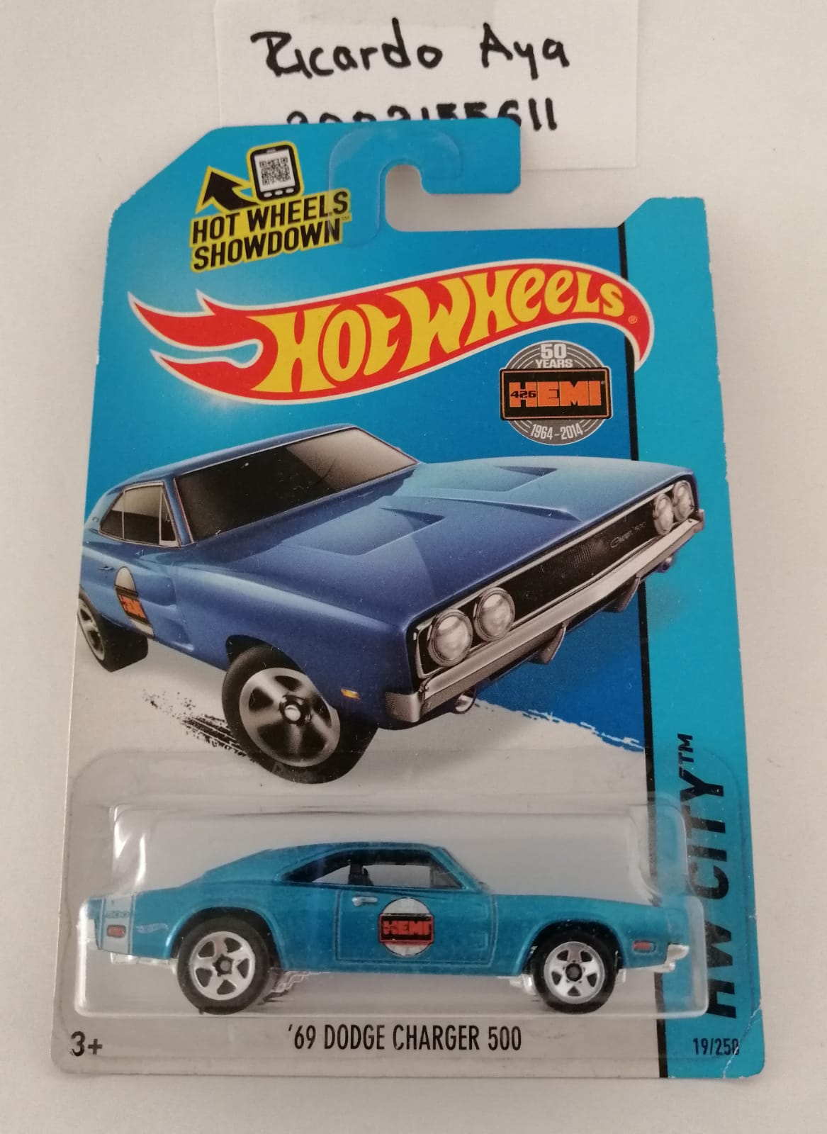 Front of satchel with blue canvas body, black straps and handle, drawstring top, and front zipper pouch.