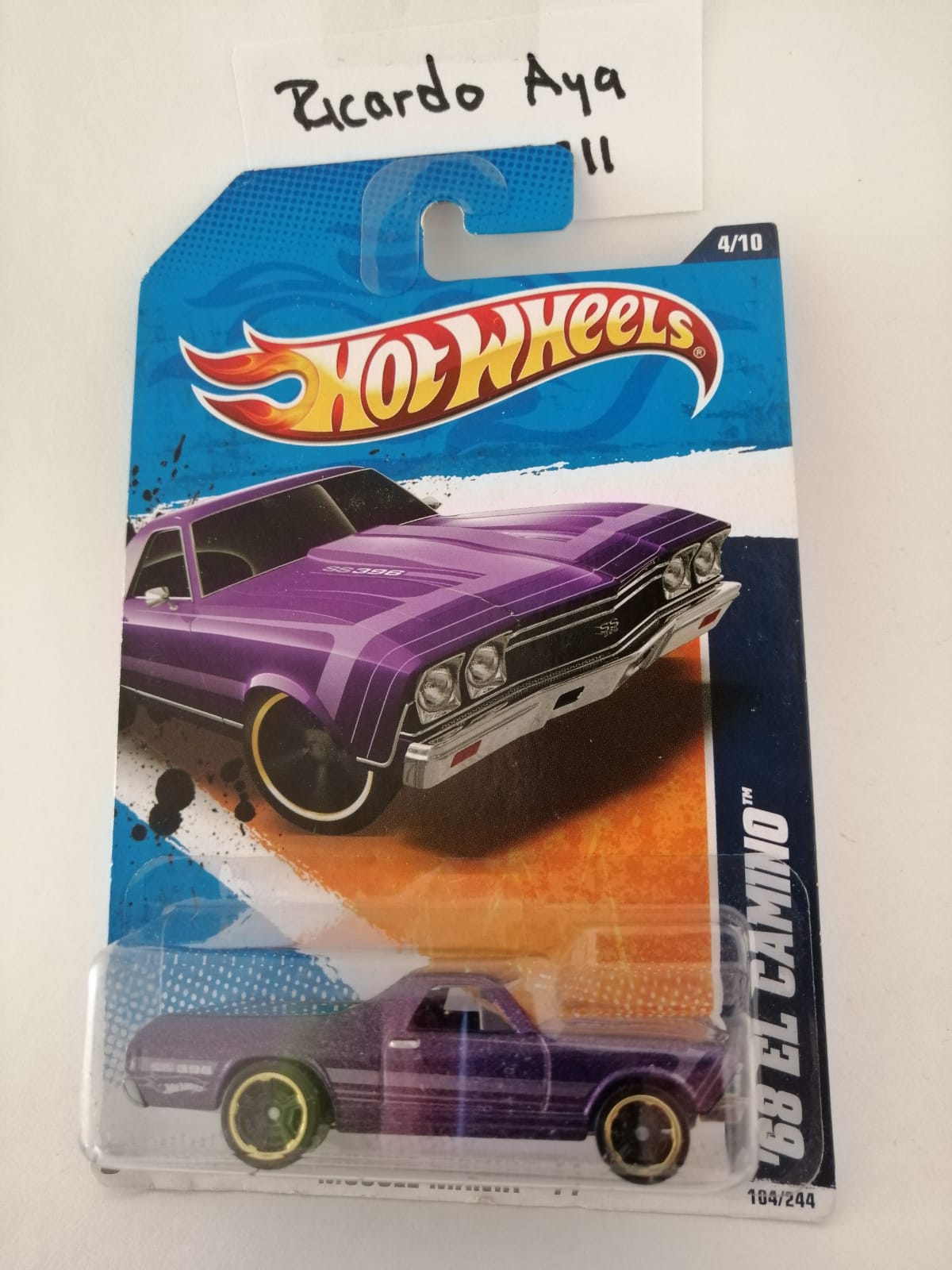 Front of satchel with blue canvas body, black straps and handle, drawstring top, and front zipper pouch.