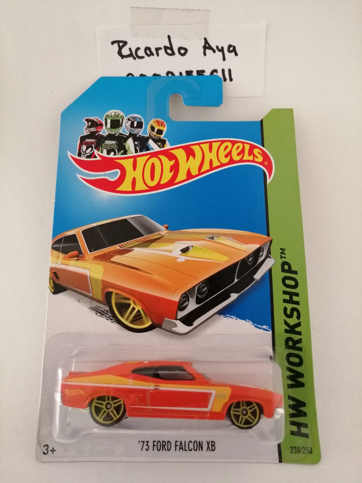 Front of satchel with blue canvas body, black straps and handle, drawstring top, and front zipper pouch.