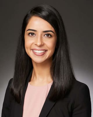 Headshot of Dr. Amneet Hans in a black blazer smiling into the camera.