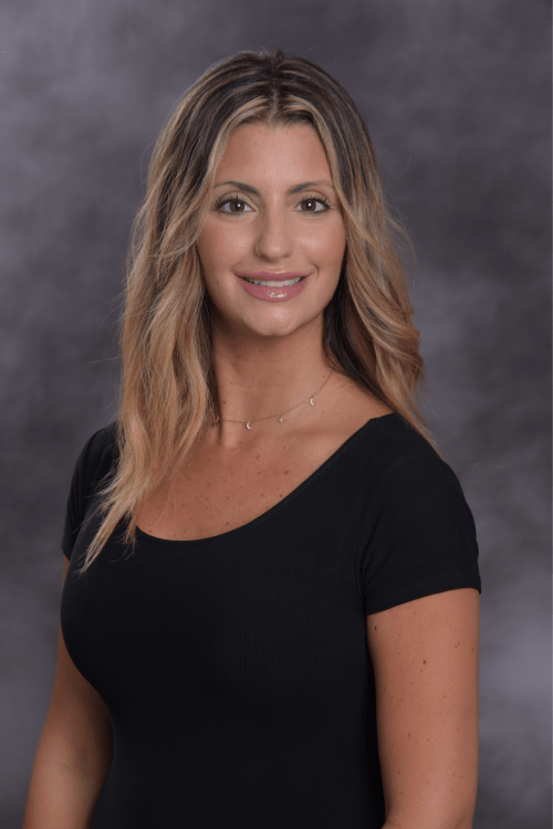 Stephanie Nask, an advanced practice provider, wearing a black shirt and gold necklace smiling into the camera.