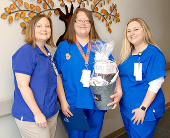 Jaimie Wheat, Med/Surg nurse manager, and Ashley Mikles, unit lead, present Laurie Butz, R.N., with the Mentorship award.