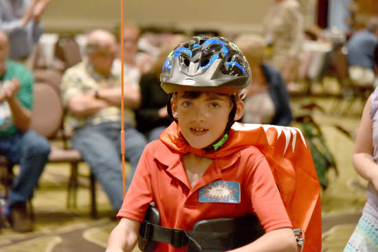 Owen Stark, 9, speeds through his laps around the ballroom on his new Amtryke.