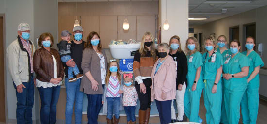 Leon and Jane Heckman and Bauer, Clayton, Laura, Ruby and Lennon Isenberg — all family members of Cohen Michael Isenberg — and Crystal Wagner and Arlene Shanks, mother and grandmother of Blake Wagner, present a CuddleCot to team members at Lake Regional Family Birth Center.