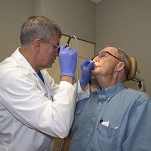 Who specializes in treatment of disease and problems related to ear, nose, and throat?