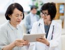 A doctor and woman look at a tablet together.