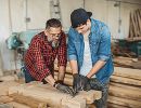 A younger and older man doing carpentry.