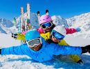 A family of skiers plays in the snow.