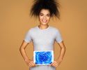 A woman holds a medical scan over her abdomen.