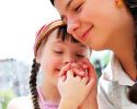 A woman holds hands with a girl who has Down syndrome.