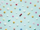 Various pills and capsules, whole and crushed, laid out in a grid.