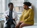 A patient and doctor talk in an exam room.
