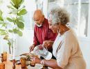 An older couple dishes up a healthy meal together.