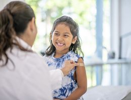 Doctor placing a bandaid on child.