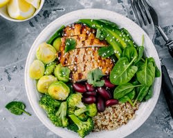 A plate of chicken, quinoa, kidney beans and green vegetables.