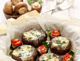 Stuffed mushrooms in a serving basket on a white tablecloth.