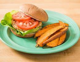 Salmon burger with a side of sweet potato fries.