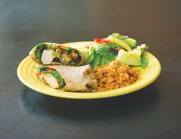 Turkey fajitas on a plate with rice and salad