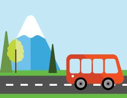Un bus en la carretera con una montaña en el fondo.