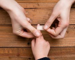 Hands bandage a child's finger