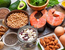 An artful grouping of protein-rich foods, including salmon, eggs, nuts, seeds and beans.