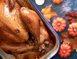 A cooked turkey in a ceramic dish.