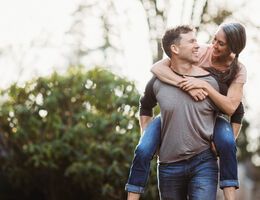 A man gives a woman a piggyback ride.