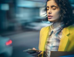 A woman holds a phone; The image is blurred to imply vertigo