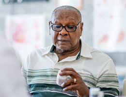 A man looks at a pill bottle.