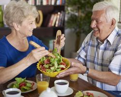 Senior couple eating salad.